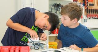 zwei Kinder bauen einen Roboter aus LEGO