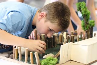 Blinder Schüler ertastet Modell von Zoogehege