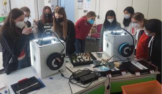 Die Mädchen verfolgen die schichtweise Entstehung ihrer maßgefertigten Bauteile im 3D-Drucker.