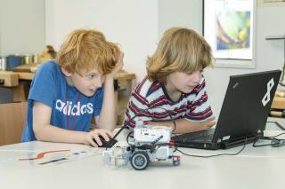 zwei Kinder programmieren einen "Robo-Hamster" aus Lego