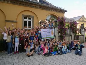 Kinder halten Auszeichnungsflagge Ferienkinder mit Flagge Biologische Vielfalt